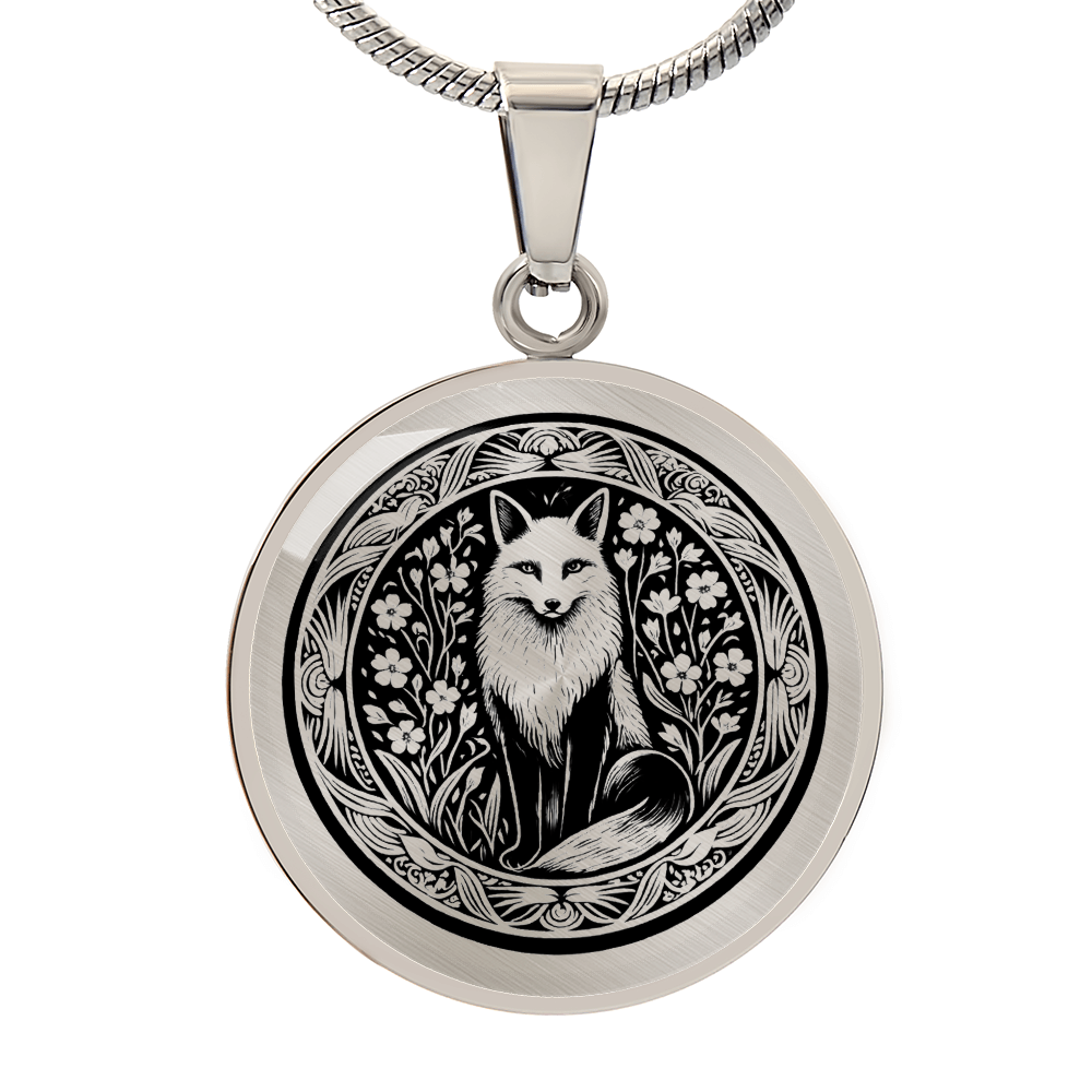 Silver circular pendant featuring an engraved fox framed by delicate botanical motifs, shown against a clean white background.