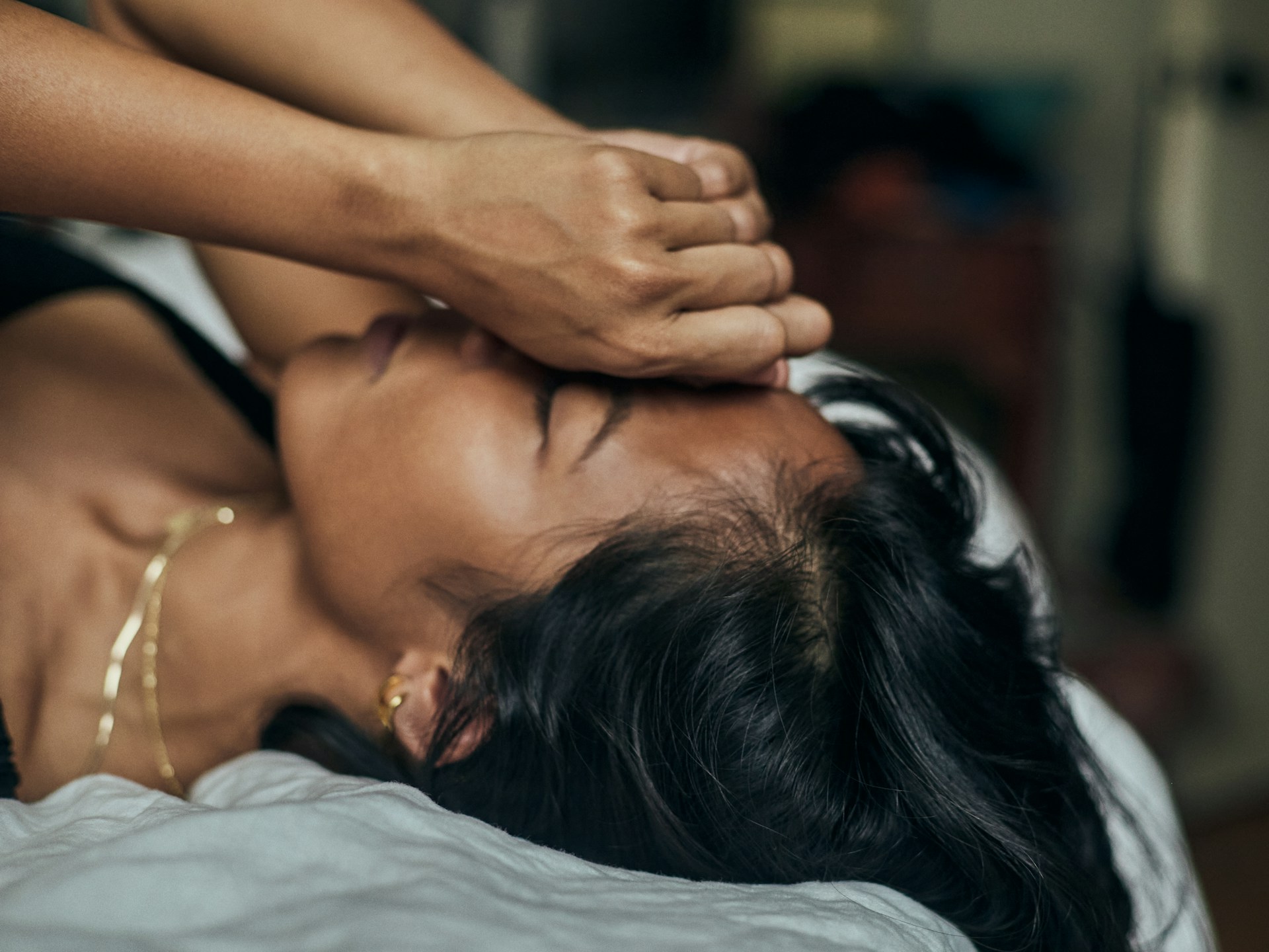 Woman covering her face while receiving emotional support from another person