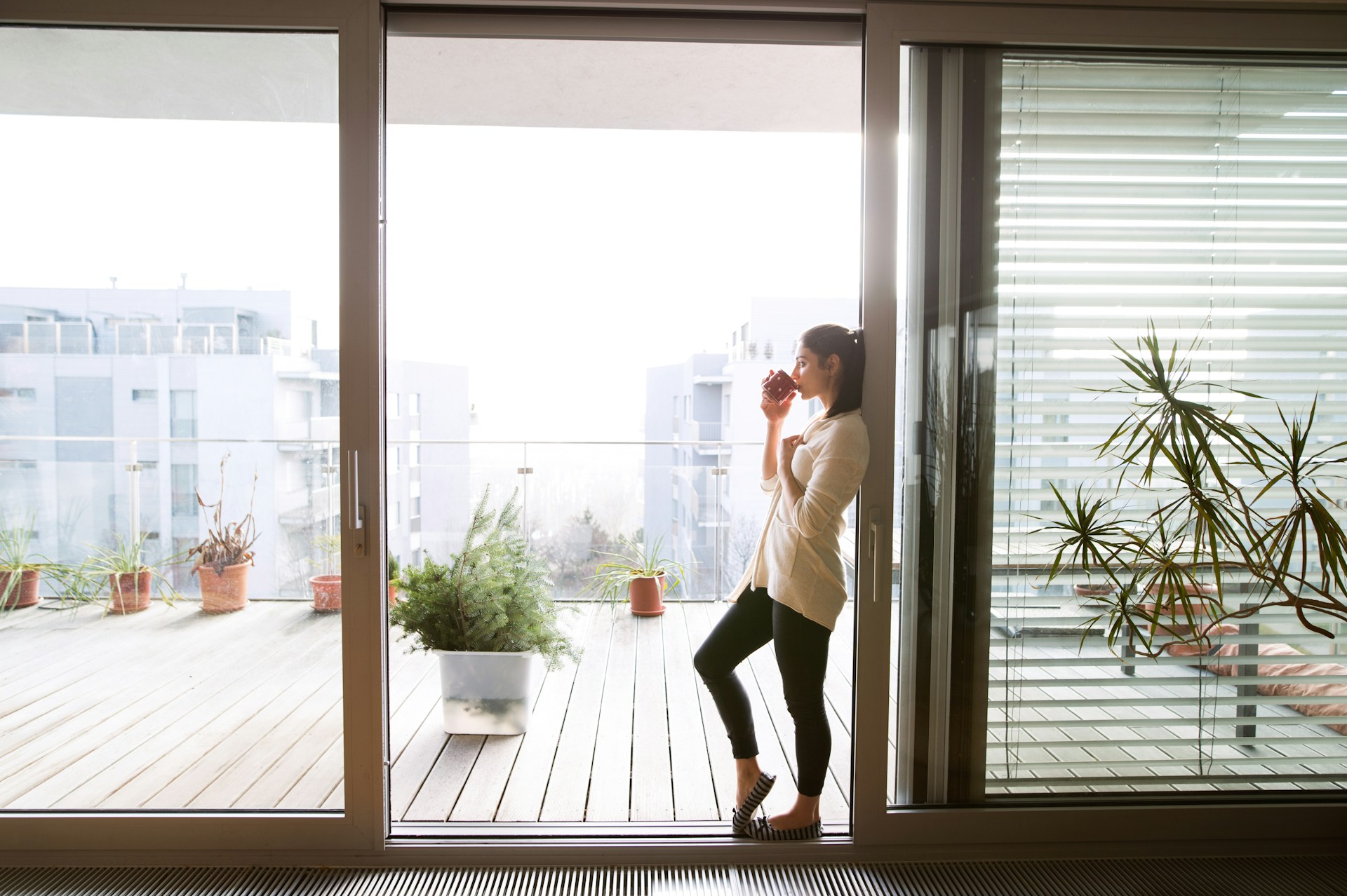 woman stand at balcony door getting used to how t be single again after a long relationship